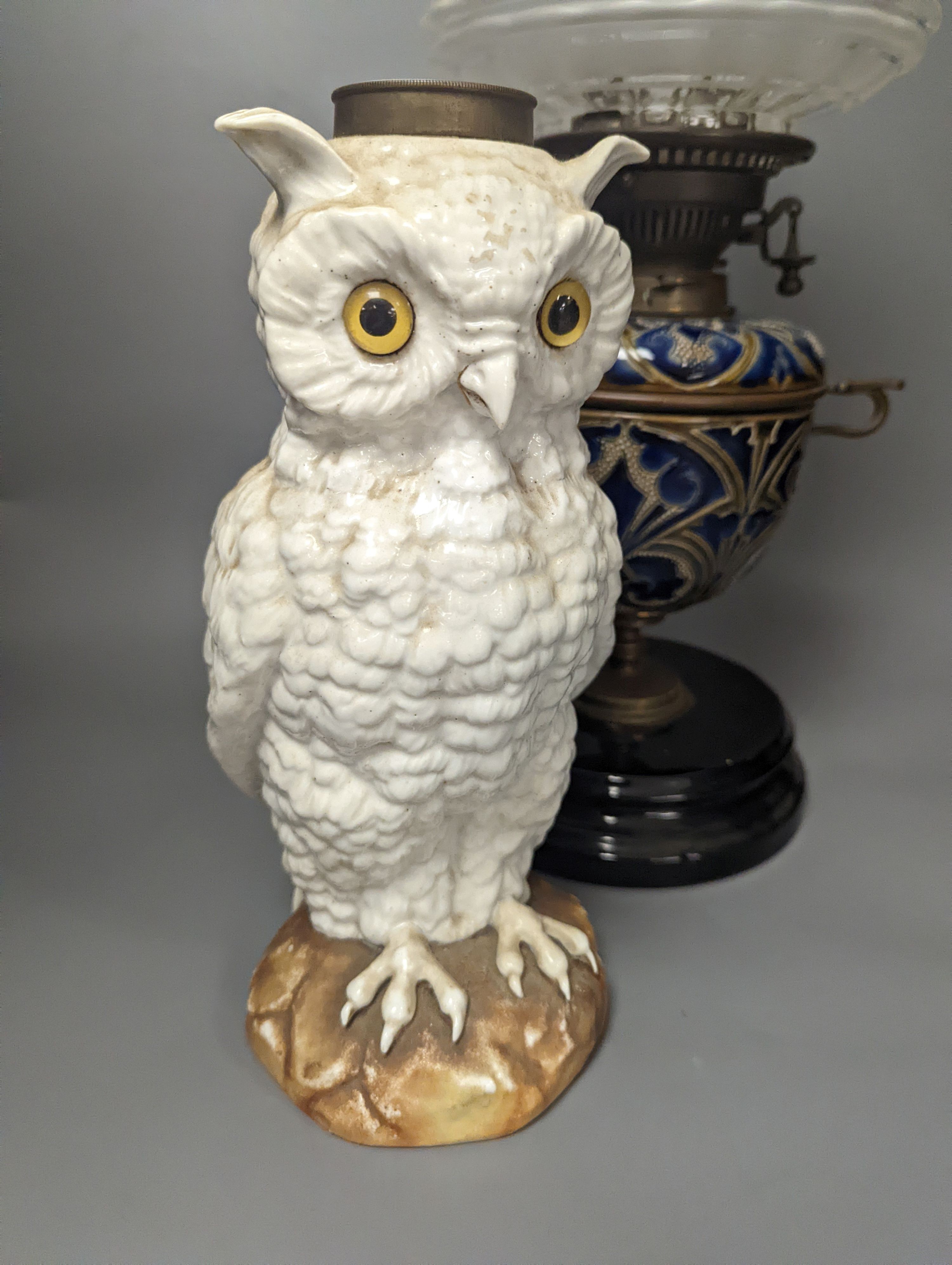 A Doulton Lambeth stoneware oil lamp and a German porcelain’owl’ lamp base, Oil lamp 54 cms high including funnel.